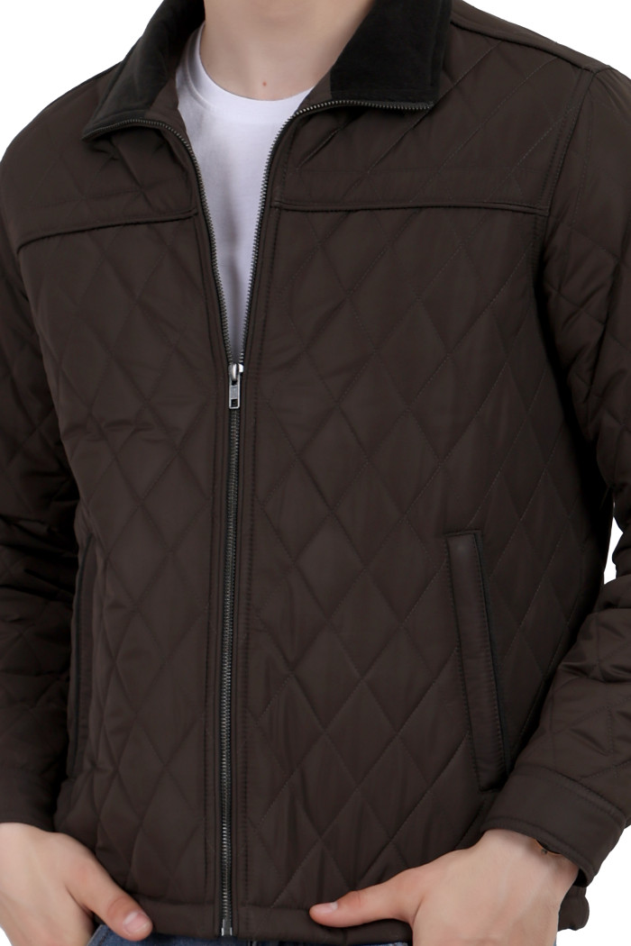 A cropped image of a man wearing a Dark Olive quilted jacket with a collar neck, zipper closure and pocket in hand designed for casual winter layering and comfort.